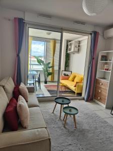 a living room with a couch and a table at Studio Vanille - Vue Mer in Saint-Denis