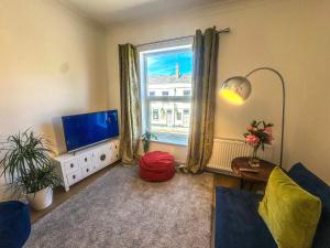 sala de estar con TV y ventana en Central Cambridge Fig Tree house en Cambridge