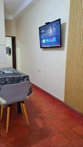 a room with a table and a television on a wall at Departamento Capital in San Fernando del Valle de Catamarca