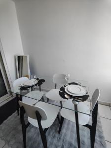 a dining room with four tables and white chairs at Studio Vanille - Vue Mer in Saint-Denis