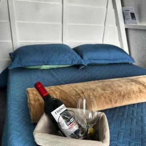 een fles wijn en glazen in een mand naast een bed bij Glamping La Mardo in Cartago