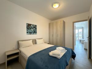 ein Schlafzimmer mit einem Bett mit zwei Handtüchern darauf in der Unterkunft Blue Horizon 2 in Nea Kallikratia