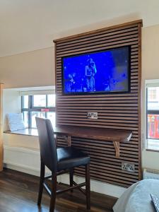 een kamer met een stoel en een televisie aan de muur bij Ridge-Rock Accommodation in Carrick on Shannon