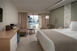 a hotel room with a bed and a desk and a kitchen at Casa Marina Beach & Reef All Inclusive in Sosúa