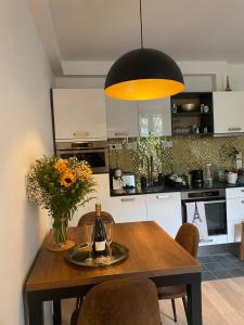 a kitchen with a wooden table with a vase of flowers at Au 55 in Vincennes