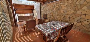 una mesa y sillas en una habitación con una pared de piedra en Casetta delle Mimose, en Isola delle Femmine