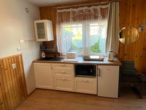 una piccola cucina con lavandino e finestra di A&R Brzozowa 5 a Rowy