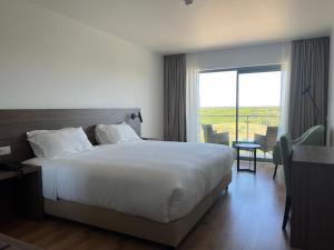 sypialnia z dużym łóżkiem i dużym oknem w obiekcie Hotel O Gato & Spa w mieście Odivelas