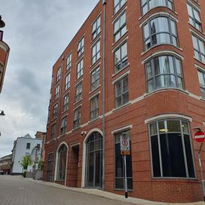 een rood bakstenen gebouw met ramen aan een straat bij A Superb One Bed Apt In The Heart Of The City in Nottingham