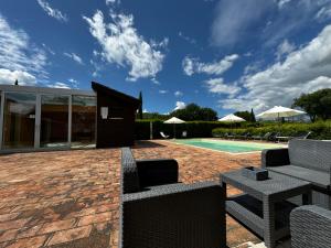a patio with chairs and a swimming pool at Agriturismo LeGi Toscana in Pietraviva