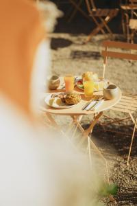 une table avec des assiettes de nourriture et des verres de jus d'orange dans l'établissement 2Places Soul, à Lörrach