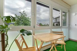 a table and chairs in a room with windows at Ferienwohnung Am Brunnen in Durbach