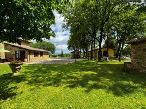 a green yard with trees and a building at Agriturismo LeGi Toscana in Pietraviva