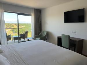 a bedroom with a bed and a balcony with a television at Hotel O Gato & Spa in Odivelas