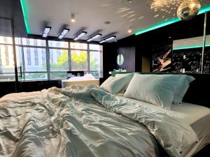 a large white bed in a room with windows at Andar de Cima Suítes in Sao Paulo