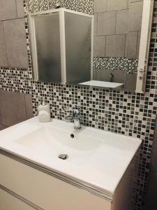 a bathroom with a white sink and a mirror at Domus KA 2 in Cremona