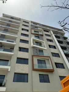 um edifício de apartamentos branco e alto com janelas em Dream of a Butterfly em Dakar