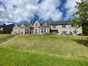 a large house on top of a grassy hill at Beinn Bhracaigh in Pitlochry