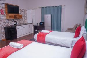 een hotelkamer met 2 bedden en een keuken bij Safi Suites and Conference Centre in Mthatha
