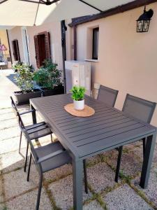 una mesa de madera y sillas con una maceta. en La Castellina 23, en Sulmona