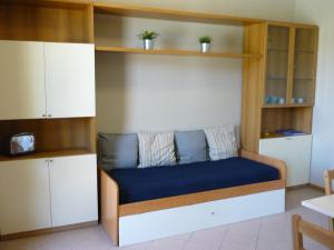 a bed in a room with wooden shelves at Villaggio Mietta in Castiglioncello
