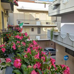 an apartment balcony with pink flowers in front of a building at B&B Stupor Mundi in Altamura