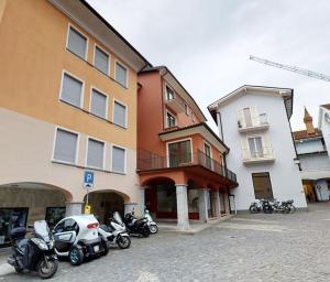 un grupo de motocicletas estacionadas frente a los edificios en Appartamento esclusivo - Piazza Grande Locarno, en Locarno