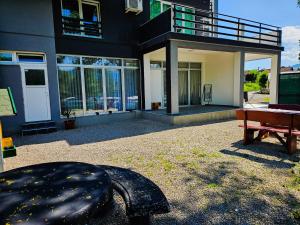 a house with a table and a bench in a yard at Apartment Bijela ladja in Bihać