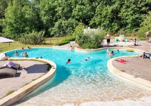 La Clairière - écolieu de vacances في Lamothe-Fénelon: مجموعة أشخاص يسبحون في مسبح