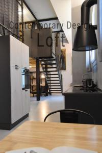 eine Küche mit einem Tisch und eine Treppe im Hintergrund in der Unterkunft Contemporary Design Loft & Apartment Padova in Padua