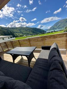 a couch on a deck with a table and a view at Loen Panorama in Stryn +9 photos