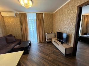 un salon avec un canapé et une télévision dans l'établissement Apart Hotel Black Sea Towers, à Batoumi
