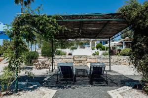 a patio with a table and chairs under a pergola at B&B Entrecolinas in Paderne