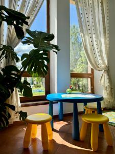 a table and two stools in front of a window at Villa Alessia in Skhidnitsa