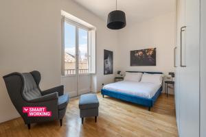 1 dormitorio con 1 cama y 1 silla en Cala Loft by Wonderful Italy, en Palermo