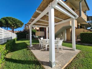 a patio with a table and chairs under a pergola at Villaggio Mietta in Castiglioncello