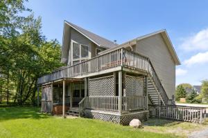 a large house with a porch and a balcony at 10 Bedroom Executive Chalet w Hot Tub in Blue Mountains