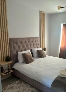 a bedroom with a large bed with white sheets and pillows at B residence - Apartment B in Iaşi