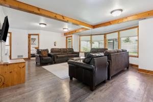 a living room with leather furniture and a flat screen tv at 10 Bedroom Executive Chalet w Hot Tub in Blue Mountains