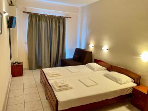 um quarto com uma cama e uma cadeira em Hotel Evagelia em Leptokarya