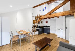 een keuken en eetkamer met een houten tafel en een ladder bij Séjour Romantique au Puy-en-Velay in Le Puy en Velay
