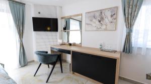 a desk in a room with a chair and a mirror at Belvedere rooms A&E in Velika Kladuša +61 photos