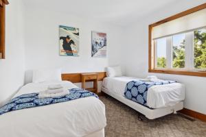 een slaapkamer met 2 bedden en een raam bij 10 Bedroom Executive Chalet w Hot Tub in Blue Mountains