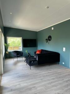 a living room with a black couch and a window at Loen Panorama in Stryn