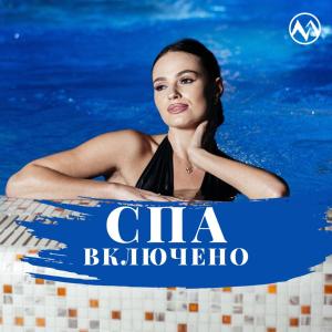 Marmaros Apart-Hotel & Spa في بوكوفِل: وجود امرأة تسبح في المسبح