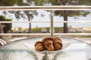 a plate of pastries sitting on a glass table at Apartmani Danilovic in Herceg-Novi