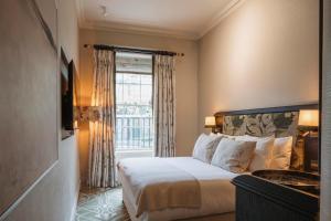 a hotel room with a bed and a window at Townhouse on the Green in Dublin