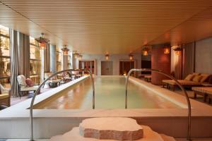 a swimming pool in a hotel lobby with a hot tub at Mondrian Bordeaux Les Carmes in Bordeaux
