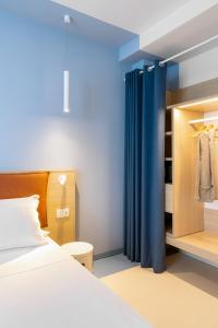 una camera con letto e tenda blu di Hotel Haway a Martinsicuro