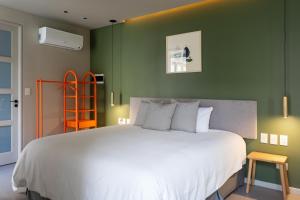 a bedroom with a large white bed with green walls at Bromelia Hotel Boutique in Buenos Aires +77 photos